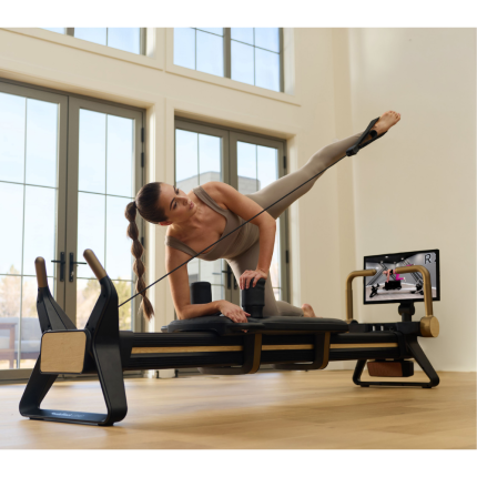 woman using NordicTrack Ultra 1 Reformer in home with 24" pivoting touchscreen for video instruction